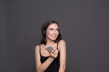 Woman listen to music in headphones, studio shot