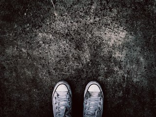 Sneakers shoes on dark grunge road background