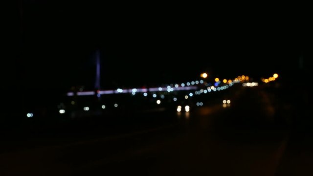 City nightlife light of cars on road. Blurred light low key dolly shot. Night city outdoors colorful light from car. Blured background night citylife. Transporttion light cars drive by night road.