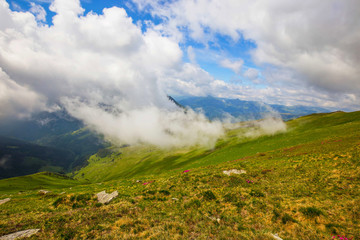 Mountain valley with clouds touching the hill , beautiful scenic summer landscape