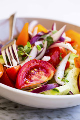 Vegetables salad closeup with tomatoes, onion , cucumber and oregano spice