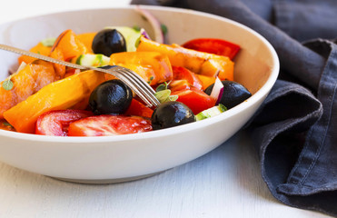 Vegetables salad closeup with tomatoes, olives,onion , cucumber and oregano spice
