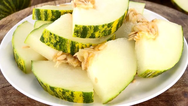Futuro Melons rotating on a wooden plate as seamless loopable 4K UHD footage
