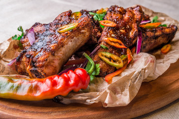 Appetizing grilled ribs decorated with hot pepper. Horizontal frame