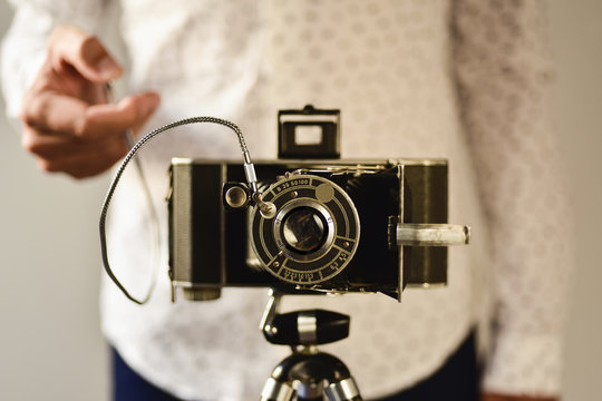 Mid section of man taking photo with vintage camera - Powered by Adobe