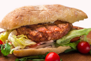 A sandwich with fried chops, herbs, tomatoes, peppers. Horizontal frame