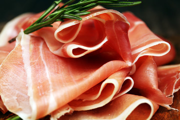 Italian prosciutto crudo or jamon with rosemary. Raw ham.