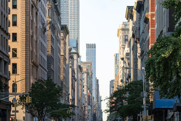 View down Fifth Avenue in Manhattan, New York City with historic buildings lining both sides of the...