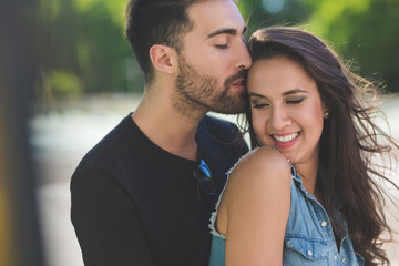 Obraz premium Handsome man kissing on head happy girlfriend