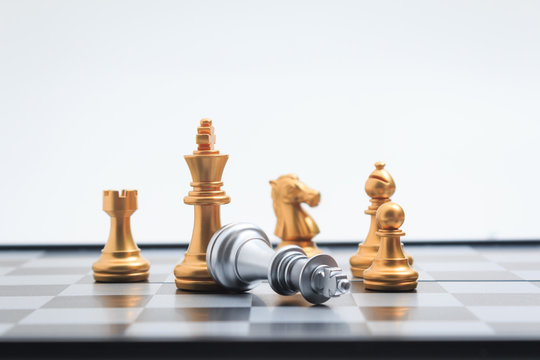 Chess board game gold player killed silver king for business competition metaphor winner and loser concept shallow depth of field