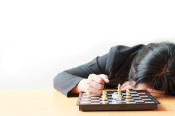 Business woman face down on the table losing in game with chess board for business challenge metaphor and lose compitition concept