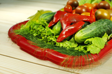 Assorted raw organic vegetables for healthy eating. Tomatoes, cucumbers, peppers and lettuce close up.