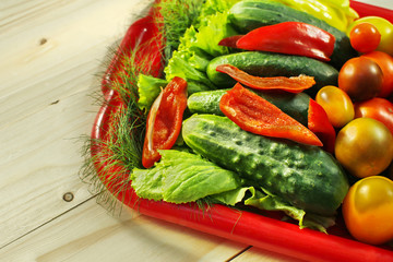 Assorted raw organic vegetables for healthy eating. Tomatoes, cucumbers, peppers and lettuce close up.