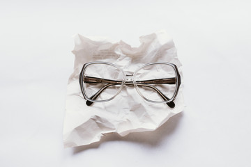 reading glasses on a wrinkled paper sheet