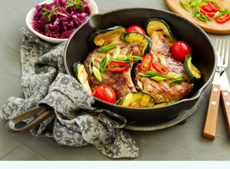 Pork cutlet on a bone with baked vegetables.