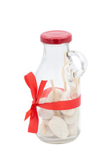 White stones in decorated glass bottle and red bow
