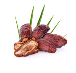 pile of dried ripe dates fruits and green palm leaf isolated on white background