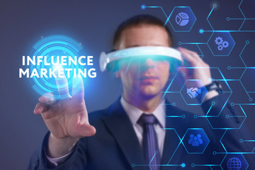 Business, Technology, Internet and network concept. Young businessman working on a virtual screen of the future and sees the inscription: Influence marketing