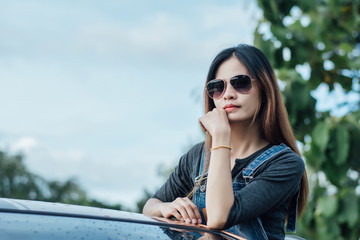 Hipster woman standing on car relax and enjoy with nature during sunset.