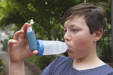 A young boy using his Asthma medication