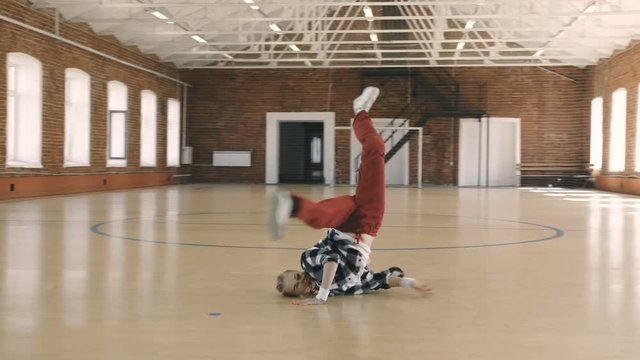 Female breakdancer dancing in sport gym. Slow motion