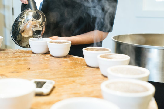 Barista Pouring Water Into Cups
