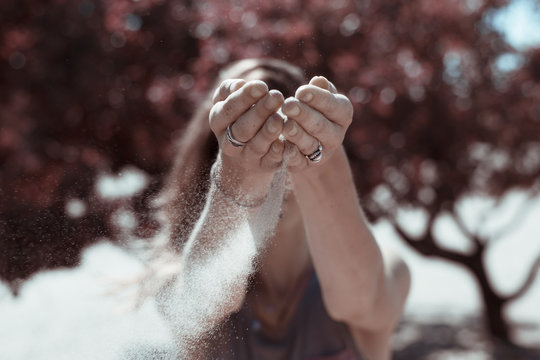 Sand released from female hands, with infrared filter.