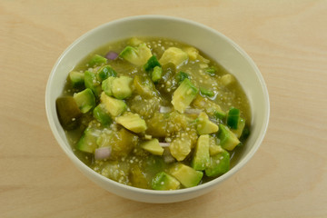 Homemade chunky avocado tomatillo salsa verde sauce or dip in white bowl