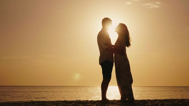Romantic young couple kissing at sunset. Against the sea