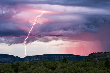 Fototapeta na wymiar Lightninng bolt and storm clouds with sunset sky