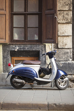 Motor scooters, parked in front of the building wall	
