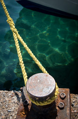 Naklejka premium Metal bollard and rope securing a ship