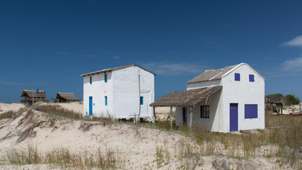 Fototapeta na wymiar Casas em meio as dunas de uma praia
