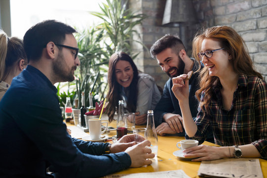 Group of young coworkers socializing in restaurant