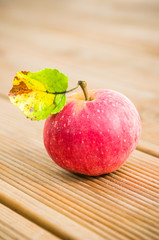 Ripe red apple with a leaf, close-up