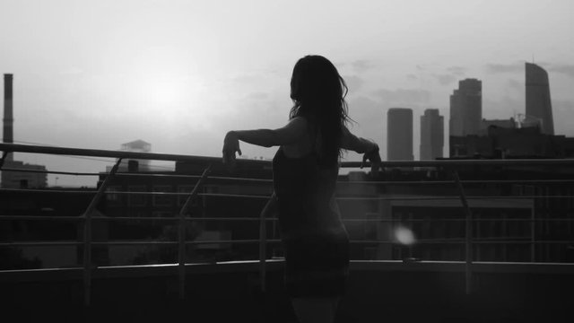 Silhouette of young woman dancing on sunset