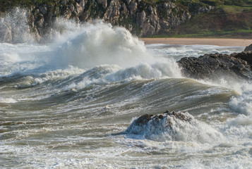 Big wave over the rocks in Cantabria