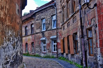An ancient street with a stone sidewalk and old walls of houses