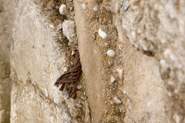 Brown and Neutral Stone Wall Background Texture With Rusty Cable