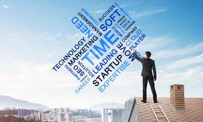 Young businessman standing on house roof and writing leadership skill concept. Mixed media