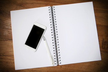 Smartphone mit Kugelschreiber und Notizblock