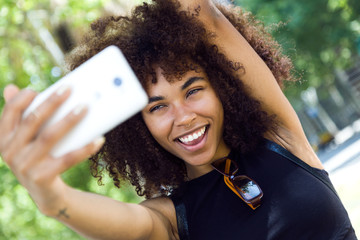 Beautiful young woman taking a selfie in the street.