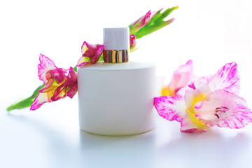 bottle of women's perfume and a delicate flower on a white background