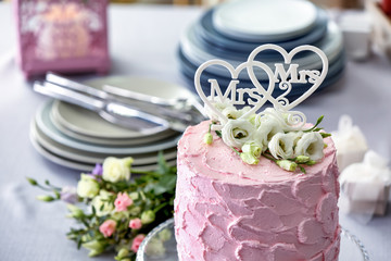 Delicious cake decorated with flowers and hearts for lesbian wedding