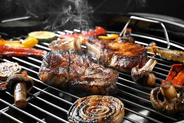 Tasty steaks and vegetables on barbecue grill