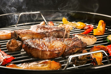 Tasty steaks and vegetables on barbecue grill