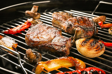 Tasty steaks and vegetables on barbecue grill