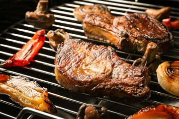 Tasty steaks and vegetables on barbecue grill