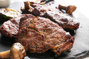 Tasty steaks on slate plate, close up