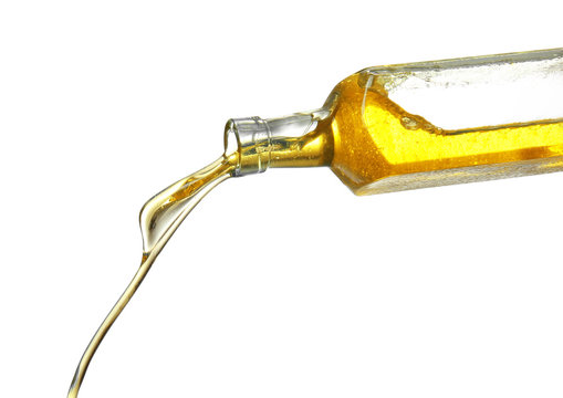 Pouring cooking oil from bottle on white background